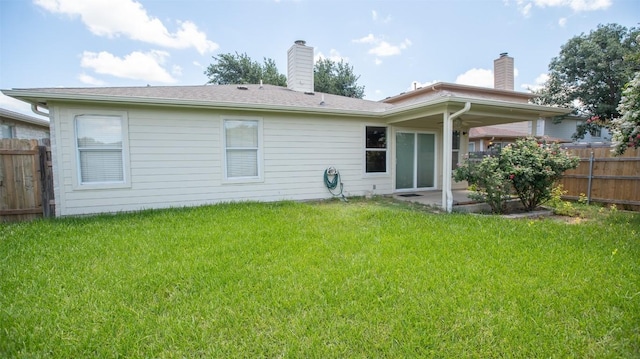 back of property with a patio and a lawn