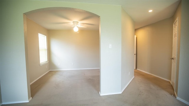 carpeted spare room featuring ceiling fan