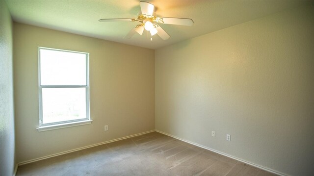 empty room featuring light carpet and ceiling fan