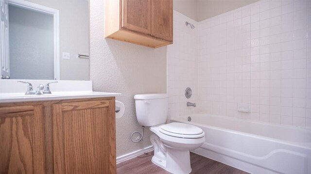 full bathroom with wood-type flooring, vanity, toilet, and tiled shower / bath combo