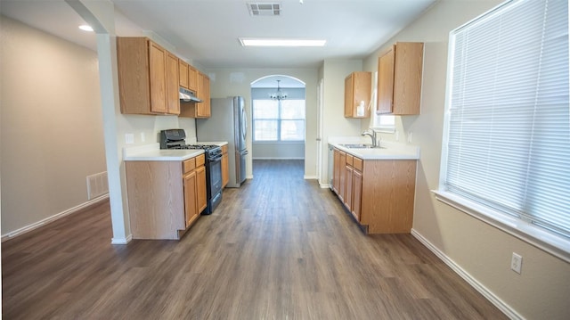 kitchen with dark hardwood / wood-style floors, sink, a chandelier, and black gas range