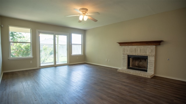 unfurnished living room with a fireplace, ceiling fan, and dark hardwood / wood-style flooring