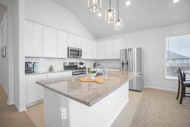 kitchen with decorative light fixtures, white cabinetry, a center island with sink, and stainless steel appliances