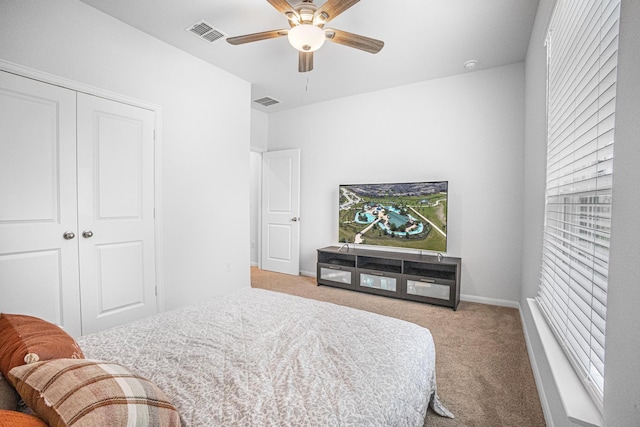 carpeted bedroom featuring ceiling fan and a closet