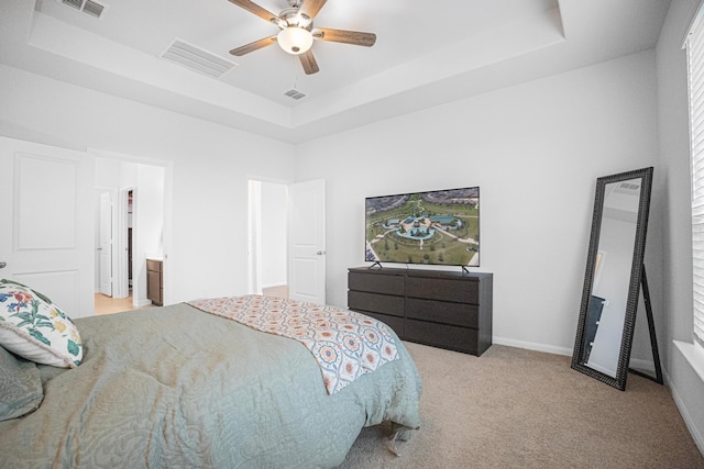 carpeted bedroom featuring ceiling fan, connected bathroom, and a raised ceiling