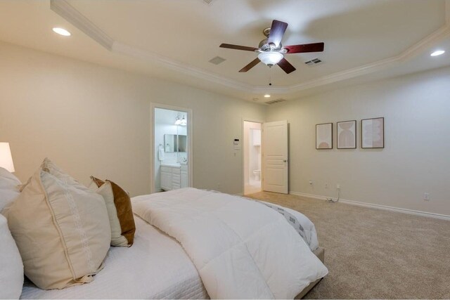 bedroom featuring connected bathroom, ceiling fan, light carpet, and a tray ceiling