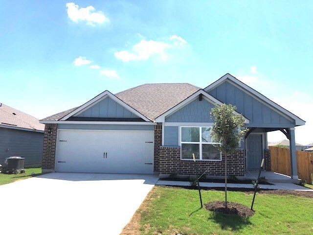 view of front of home featuring cooling unit, a front yard, and a garage