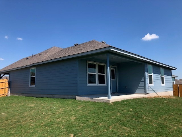 back of property with a lawn and a patio