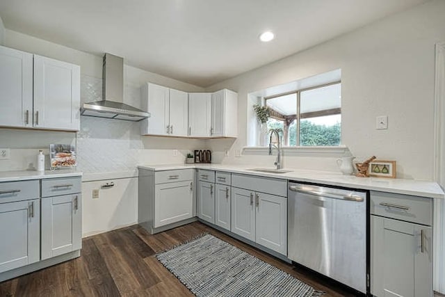 kitchen featuring gray cabinetry, wall chimney range hood, dark hardwood / wood-style flooring, sink, and stainless steel dishwasher