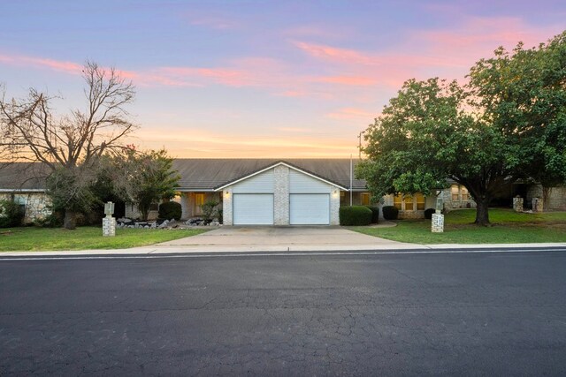 ranch-style home with a yard and a garage