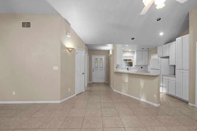 kitchen with white cabinets, ceiling fan, light tile flooring, and kitchen peninsula