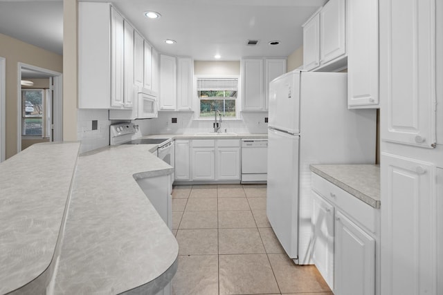 kitchen with white appliances, white cabinets, sink, tasteful backsplash, and light tile floors