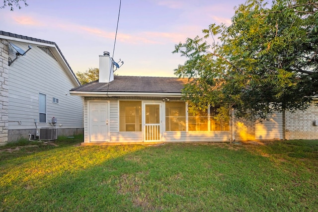 exterior space with central AC and a yard