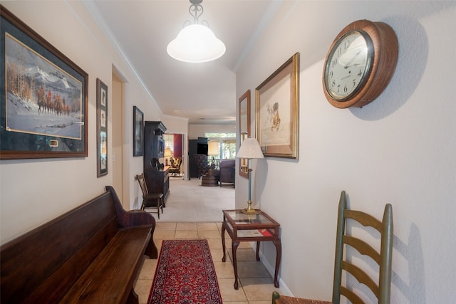 hallway with ornamental molding and light carpet