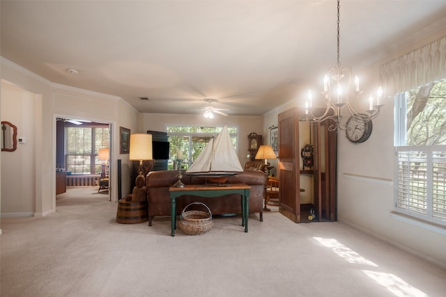 living room featuring crown molding, ceiling fan with notable chandelier, and light colored carpet