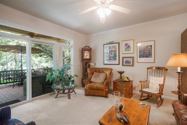 sitting room with ornamental molding, carpet, and ceiling fan