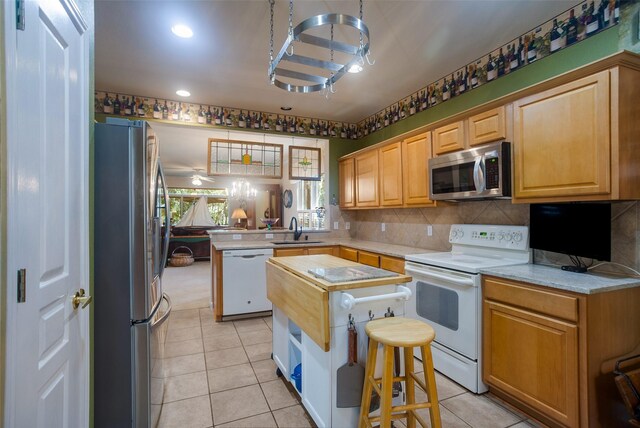 kitchen featuring sink, appliances with stainless steel finishes, decorative backsplash, and light tile patterned floors