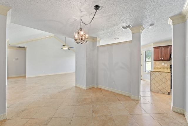 spare room with a textured ceiling, light tile patterned flooring, crown molding, ceiling fan with notable chandelier, and ornate columns