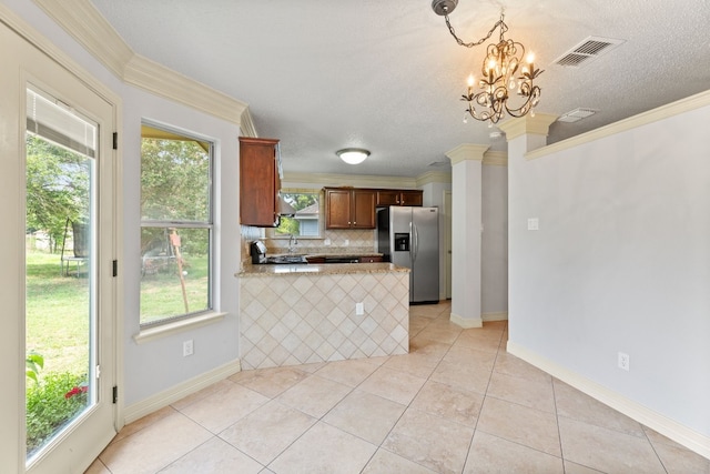 kitchen featuring ornamental molding, kitchen peninsula, hanging light fixtures, and stainless steel fridge