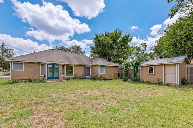 view of front of home with a storage unit, a front yard, and french doors