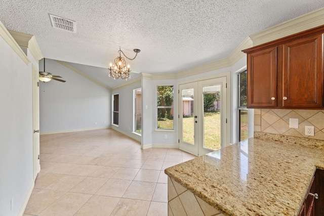 interior space with tasteful backsplash, light tile patterned floors, light stone countertops, lofted ceiling, and ornamental molding