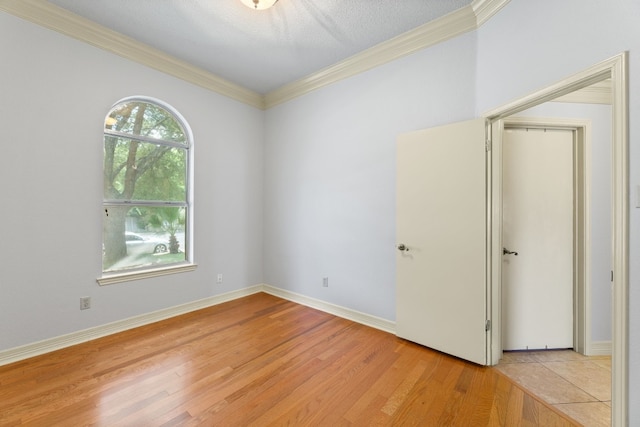 unfurnished room featuring light hardwood / wood-style flooring and crown molding