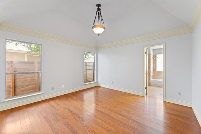 spare room featuring hardwood / wood-style flooring, vaulted ceiling, and ornamental molding