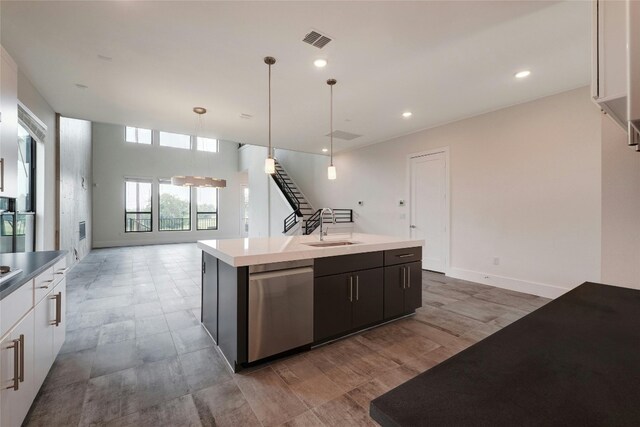 kitchen featuring visible vents, a sink, light countertops, dishwasher, and open floor plan