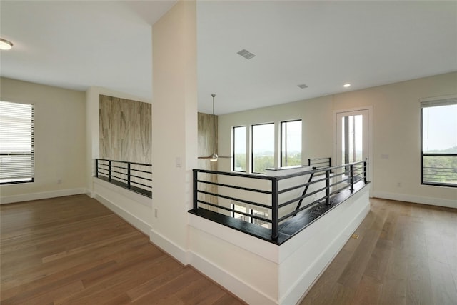 corridor with recessed lighting, visible vents, baseboards, and wood finished floors