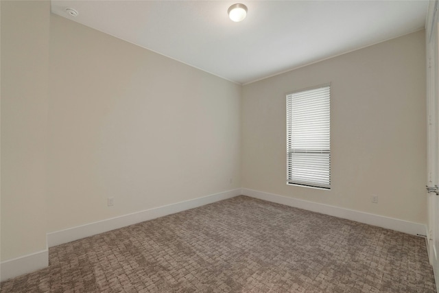 unfurnished room featuring light colored carpet and baseboards