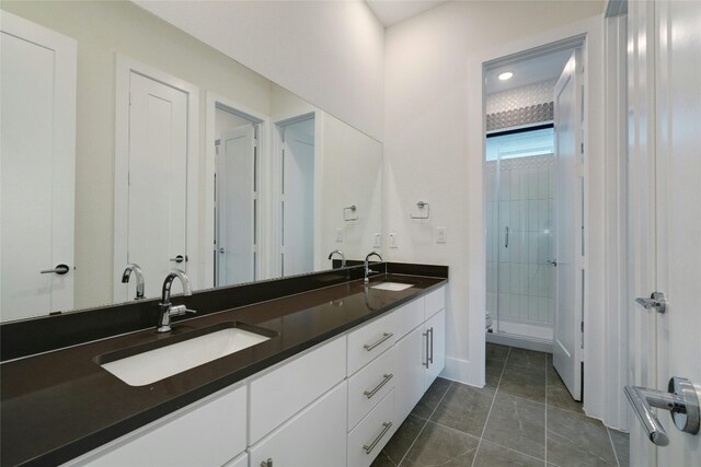 full bath featuring tile patterned flooring, a shower stall, double vanity, and a sink