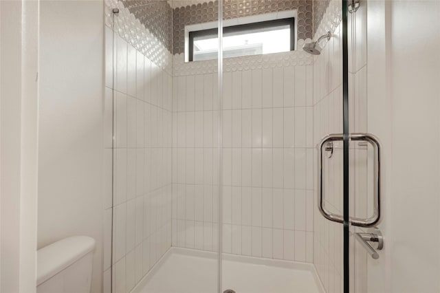 full bath featuring toilet and a stall shower