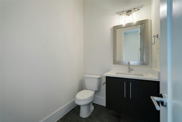 bathroom with tile patterned flooring, toilet, vanity, and baseboards