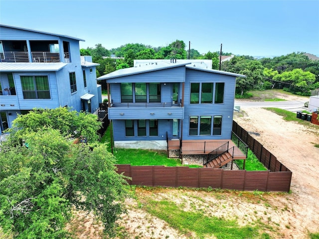 rear view of property featuring stairway and dirt driveway