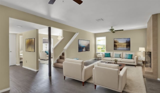 living room featuring ceiling fan and dark hardwood / wood-style flooring