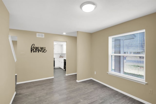 empty room with dark wood-style floors, baseboards, and recessed lighting