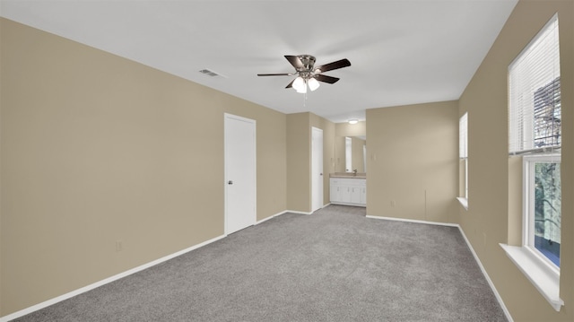 carpeted spare room with a ceiling fan, healthy amount of natural light, and baseboards