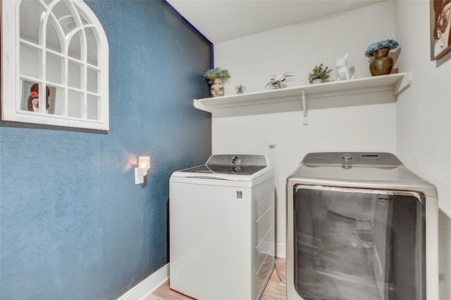 laundry room featuring light hardwood / wood-style floors and washing machine and clothes dryer