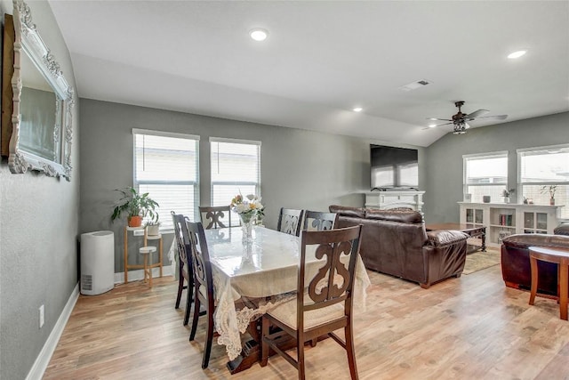 dining space featuring ceiling fan, a healthy amount of sunlight, vaulted ceiling, and light wood-type flooring