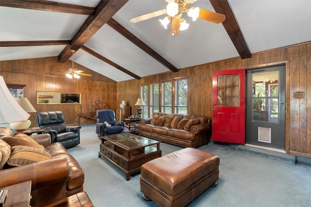 living room with vaulted ceiling with beams, wood walls, carpet flooring, and ceiling fan