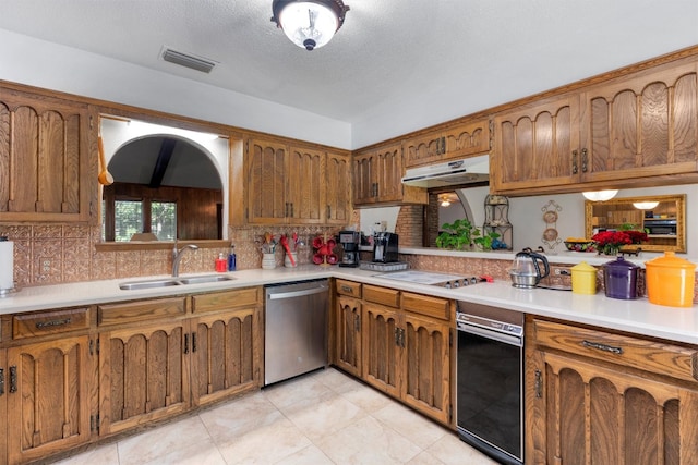 kitchen featuring tasteful backsplash, white gas stovetop, a textured ceiling, stainless steel dishwasher, and sink