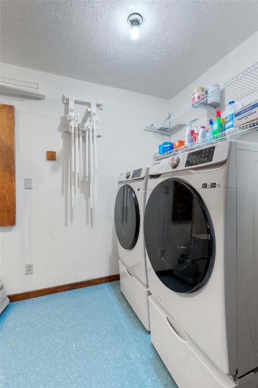 laundry room featuring washing machine and dryer and a textured ceiling