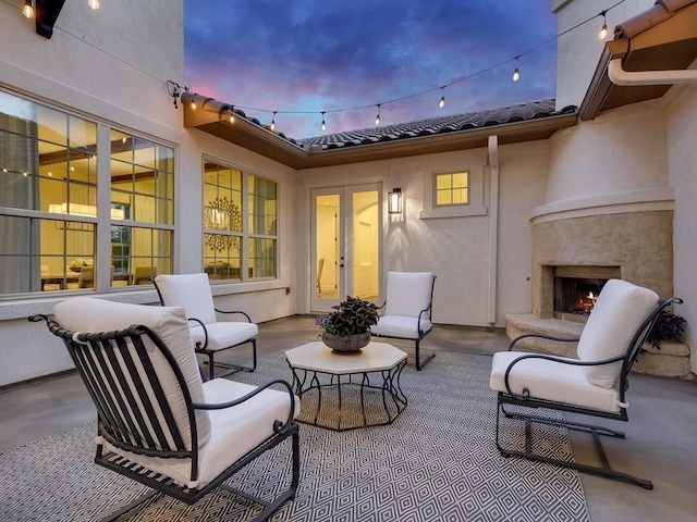 patio terrace at dusk with exterior fireplace