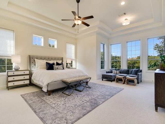 bedroom with ceiling fan, a raised ceiling, carpet floors, and a towering ceiling