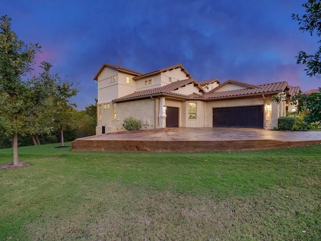 mediterranean / spanish-style house featuring a yard and a garage