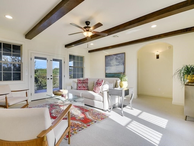 living room featuring french doors, carpet flooring, beam ceiling, and ceiling fan