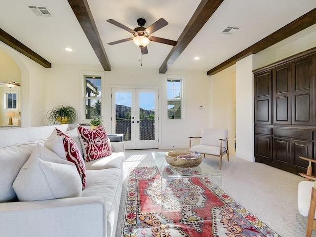 living room with french doors, ceiling fan, beam ceiling, and light colored carpet