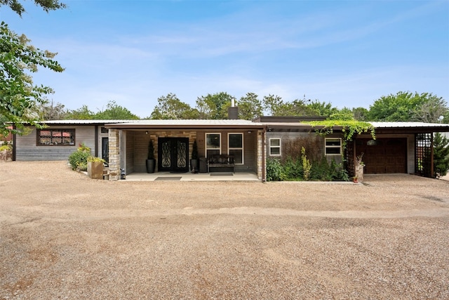 ranch-style house featuring a garage and a carport