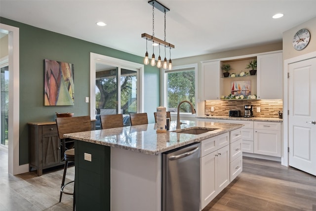 kitchen featuring white cabinetry, a kitchen island with sink, sink, tasteful backsplash, and dishwasher