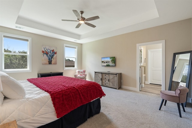 bedroom with ceiling fan, a raised ceiling, and carpet flooring